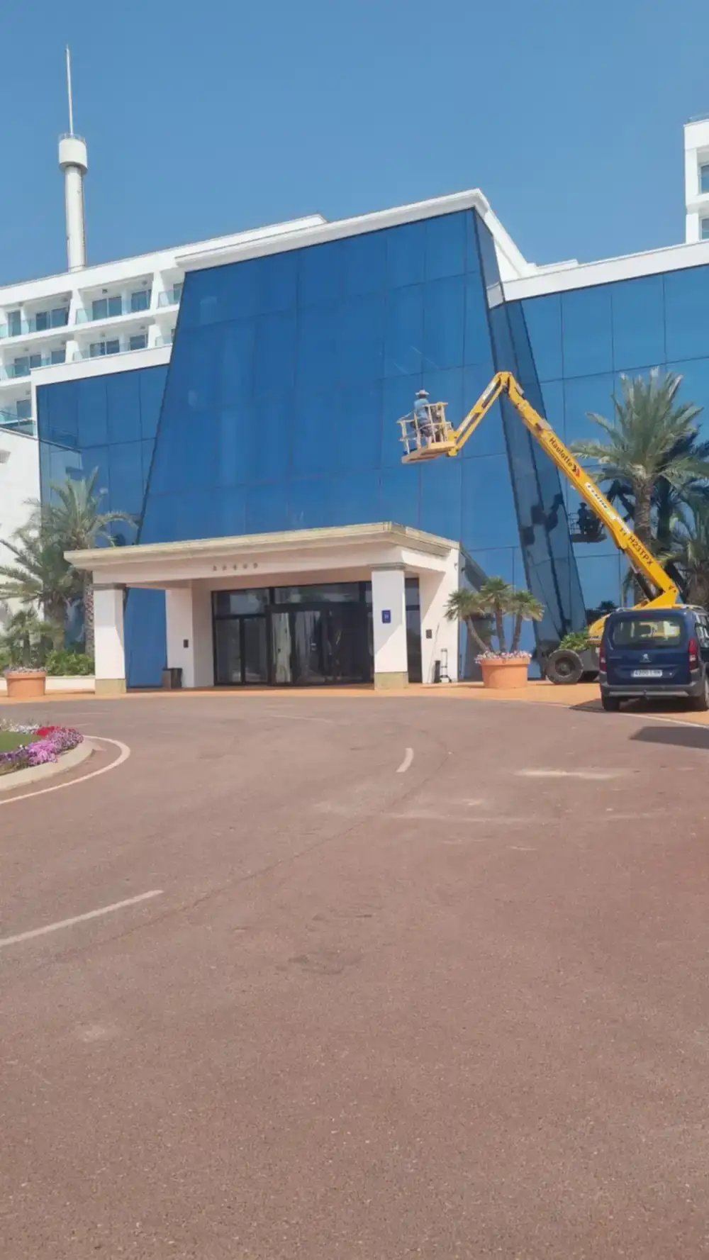 Grúa articulada para limpieza de cristales en altura con medidas de seguridad.